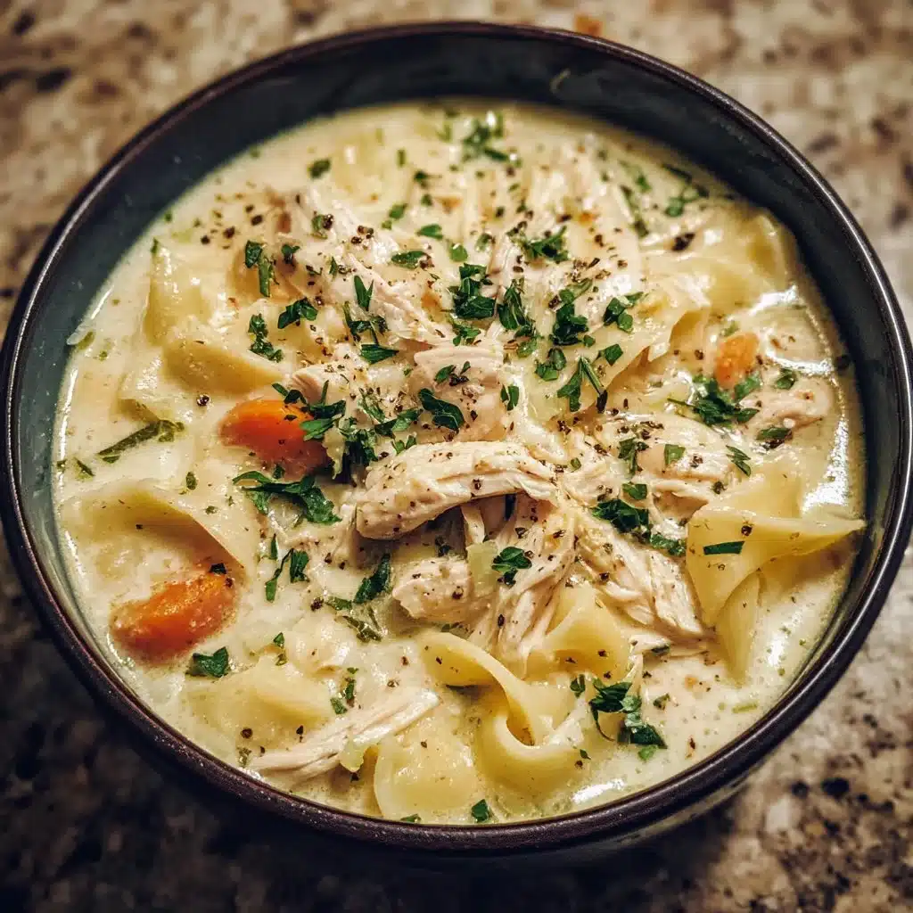 Crockpot Chicken Alfredo Soup in a bowl garnished with fresh herbs