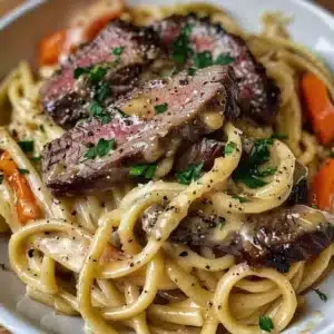 Cowboy Butter Steak Linguine 3 Delicious Cowboy Butter Steak Linguine served on a plate with a side of vegetables.