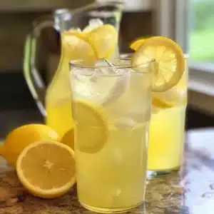 Glass of fresh squeezed lemonade with lemon slices and mint garnish