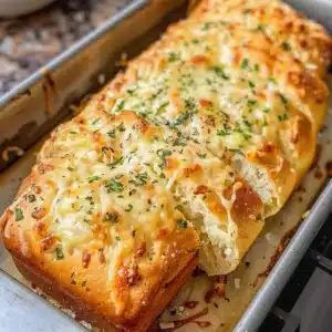 Garlic Parmesan Cottage Cheese Bread Recipe 3 Loaf of Garlic Parmesan Bread with herbs and cheese on a wooden board.